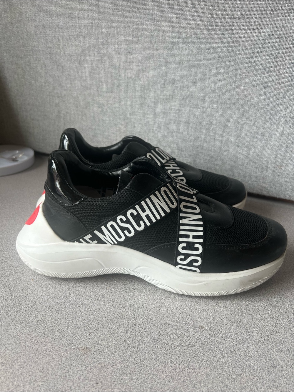 Moschino Black and White Logo Strap Slip-On Sneakers with Red Heel Accent